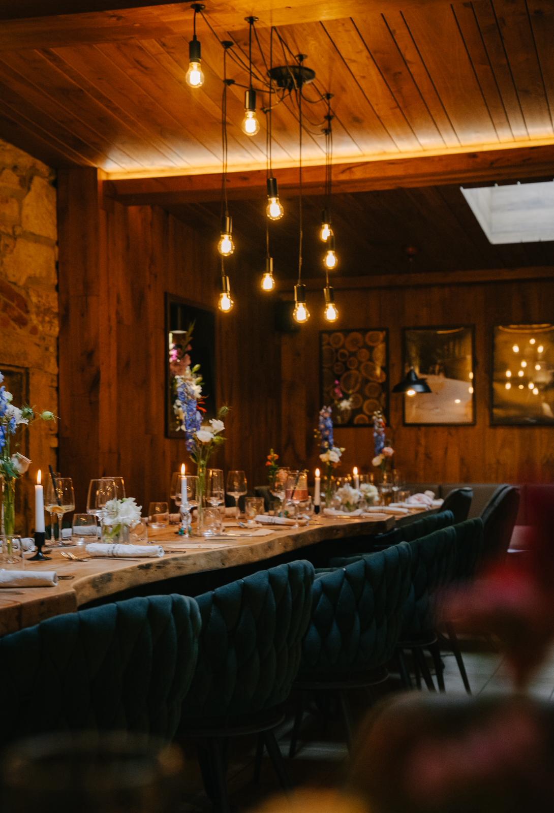 Gemütlicher Gastraum im HOFZWANZIG mit Holz, Stein und Blumendekoration